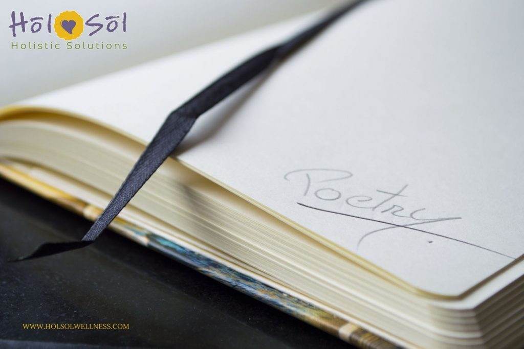Close-up of an open notebook with the word "Poetry" written on the page next to a black ribbon bookmark. The notebook is partially closed, and text on the image reads "Hol Sol Holistic Solutions," perfectly blending creativity and mindfulness.