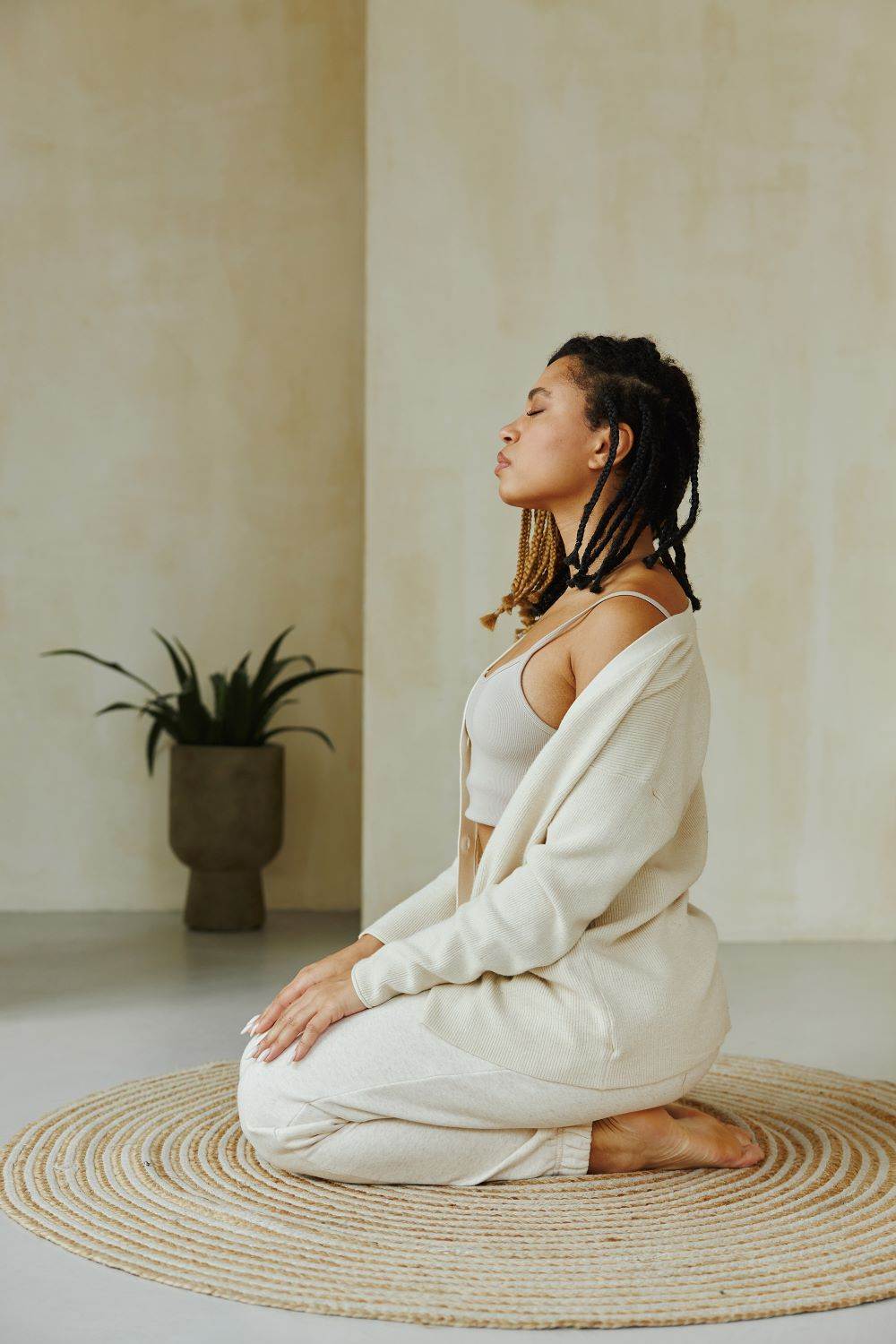 SSS Grounded 19 Vagrasana 1000x1500 Image woman with long dark hair wearing a CGM at sunset with wam welcoming look on her face. She's wearing a blue dress and holding an essential oil bottle